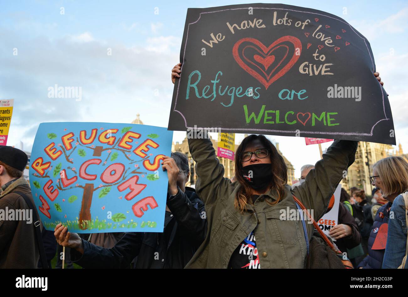 A protestor holds a placard during the demonstration. Demonstrators gathered in Parliament Square in support of refugees Stock Photo