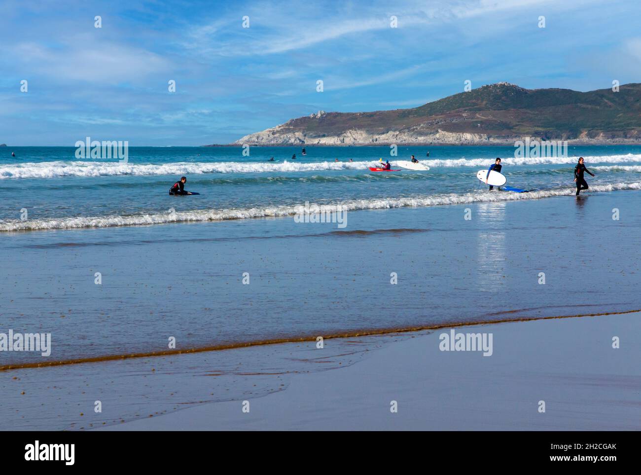 Surfers on the sandy beach at Woolacombe on the North Devon coast England UK close to the South West Coast Path. Stock Photo