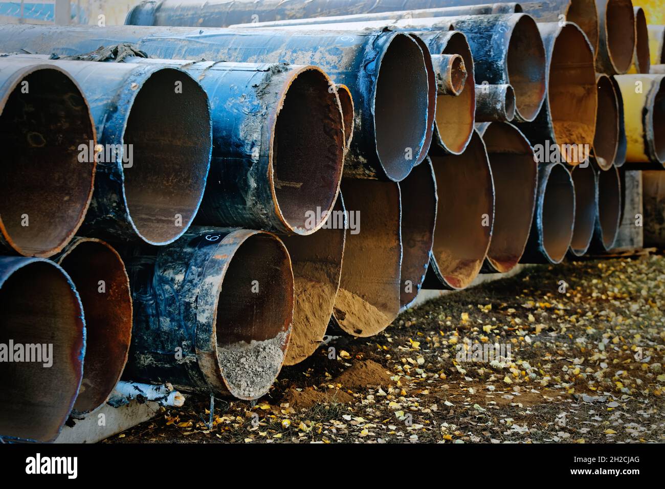 Old wornout pipes for gasification are laid in a row. Scrap metal