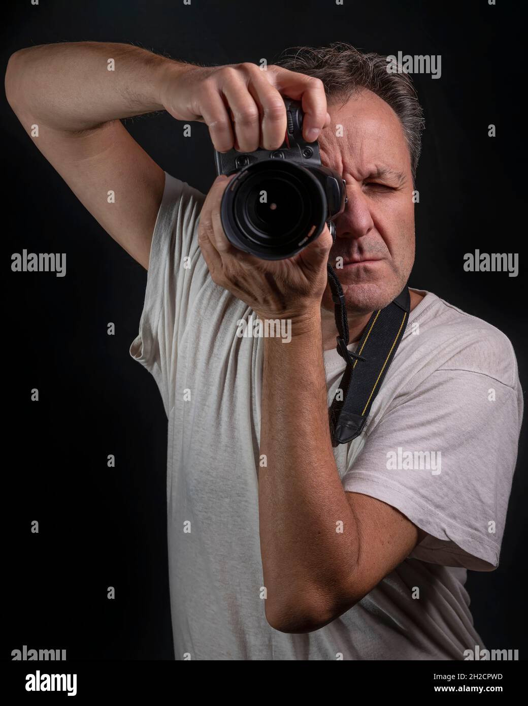 A professional photographer half-length portrait while taking a photograph Stock Photo