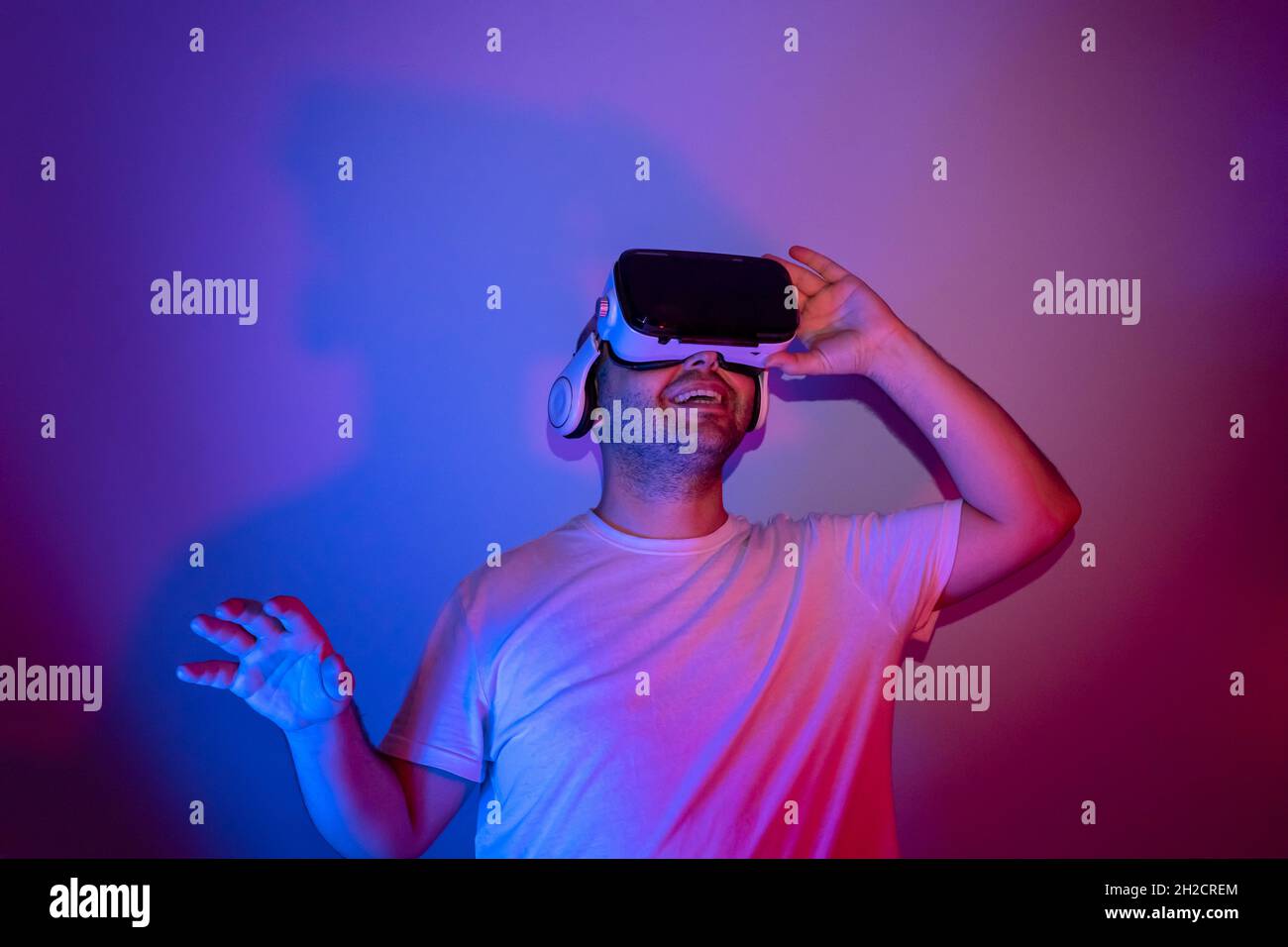 young man using virtual reality glasses is getting happy. Stock Photo