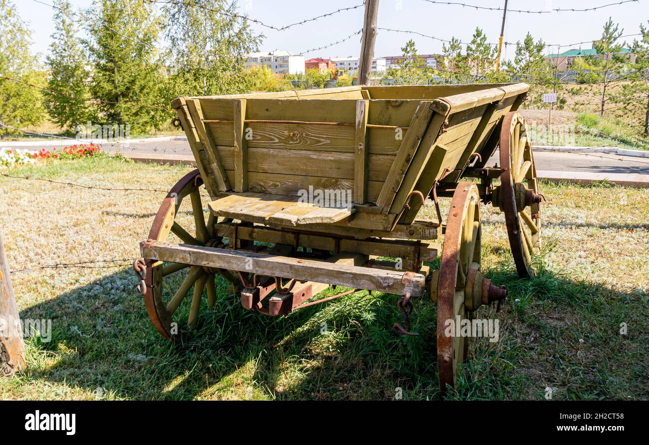 Wooden carriage from 1940s beside barbed wire fence. ALZHIR museum and memorial complex of political repressions  Aqmola, Nur-Sultan, Kazakhstan Stock Photo