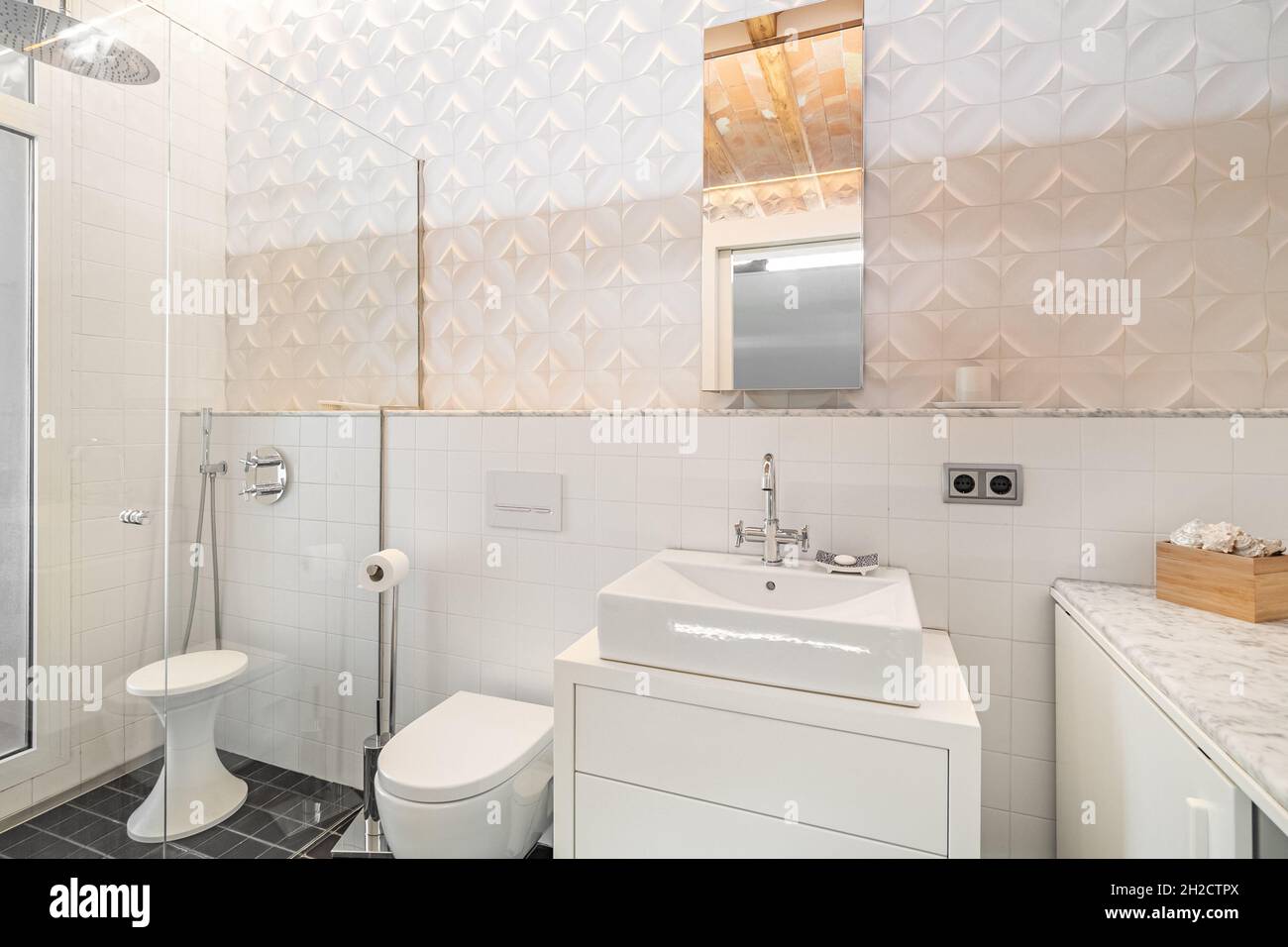 Modern refurbished tiled bathroom with shower zone, toilet, white sink
