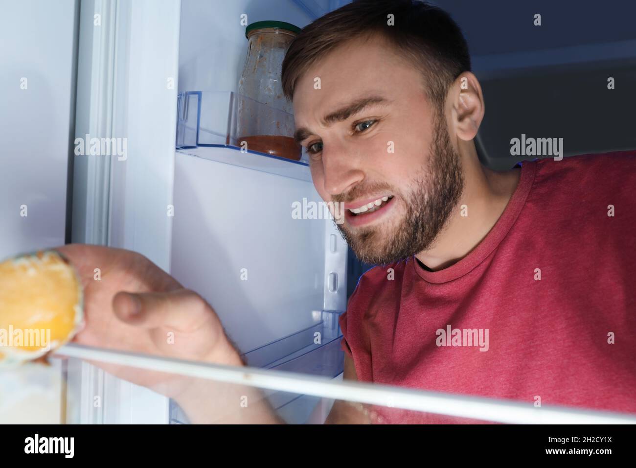 Man smelling stinky stale cheese in refrigerator Stock Photo Alamy