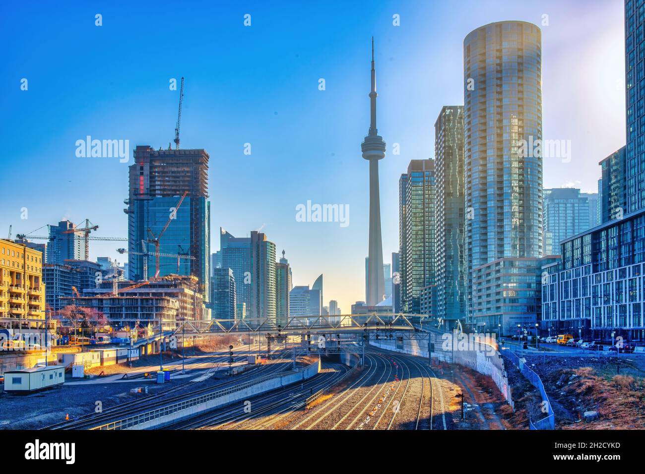 The CN Tower and the Toronto skyline seen in the early morning. Sunbeams can be seen coming between the buildings. Stock Photo