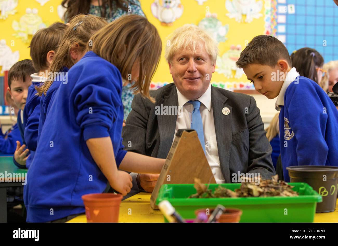 Prime Minister Boris Johnson joins schoolchildren as they make a bug hotel during a visit to Crumlin Intergrated primary school in County Antrim. Picture date: Thursday October 21, 2021. Stock Photo