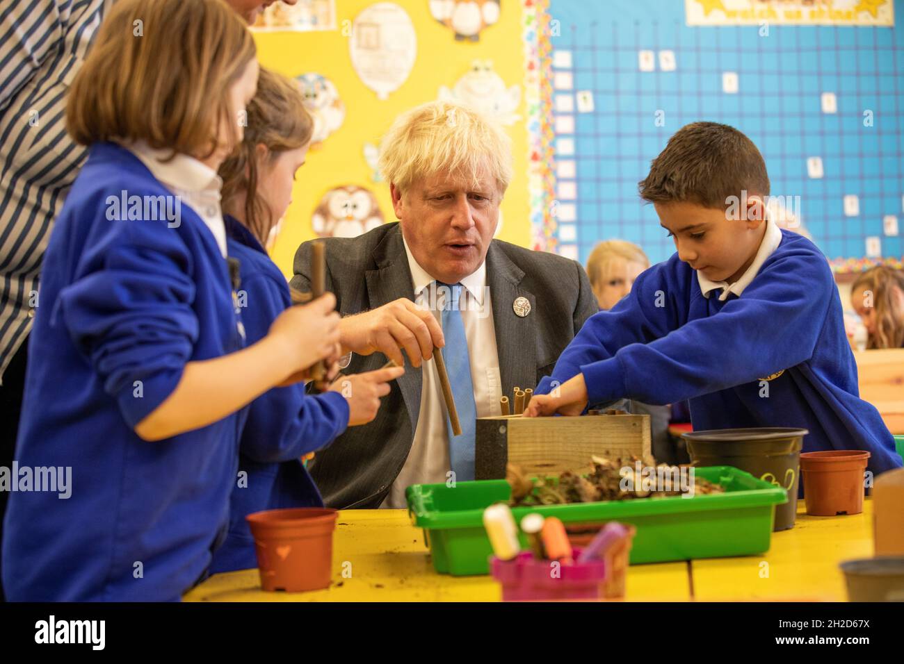 Prime Minister Boris Johnson joins schoolchildren as they make a bug hotel during a visit to Crumlin Intergrated primary school in County Antrim. Picture date: Thursday October 21, 2021. Stock Photo