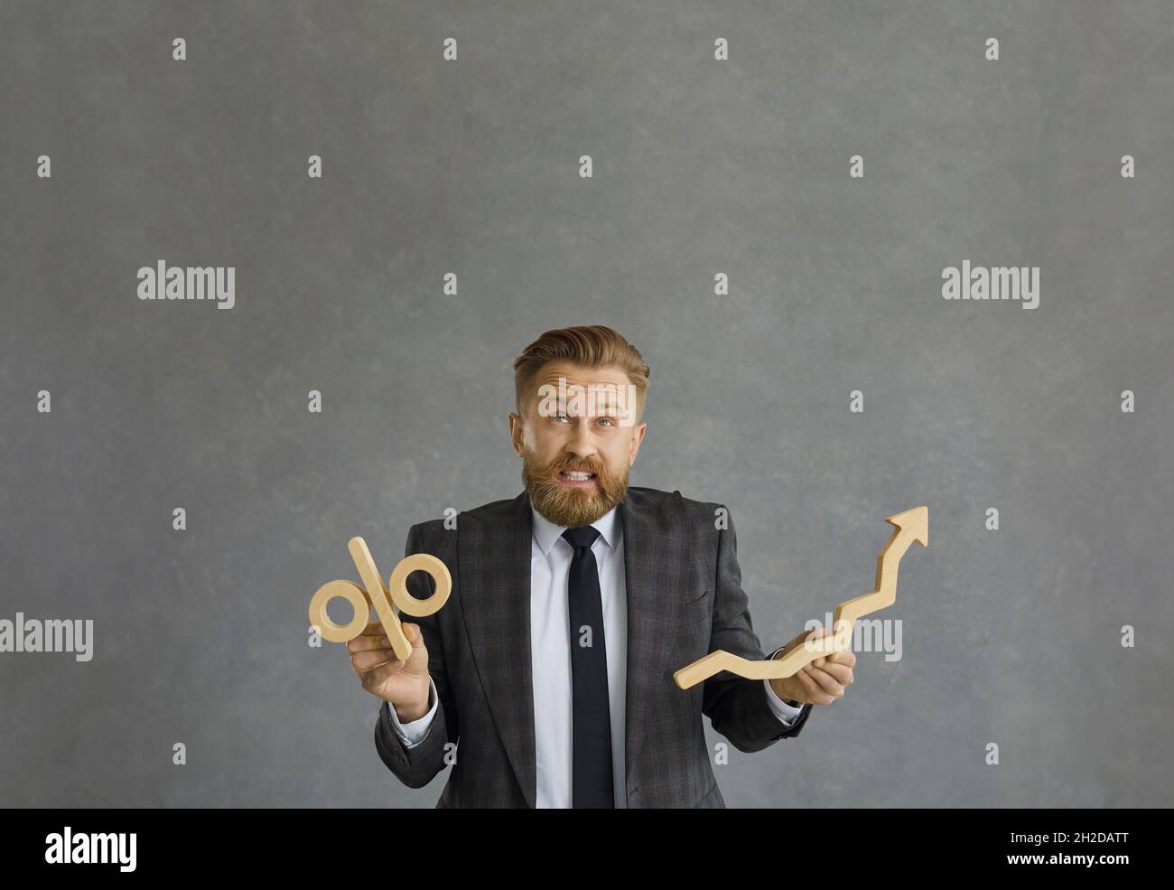 Funny businessman confused about money investment holding percent and arrow symbols Stock Photo