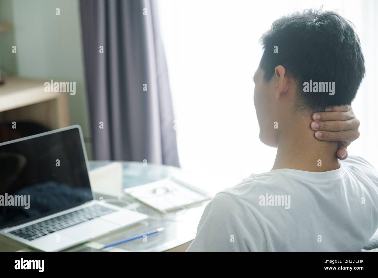 office syndrome - man suffering from neck and back pain while working with computer Stock Photo