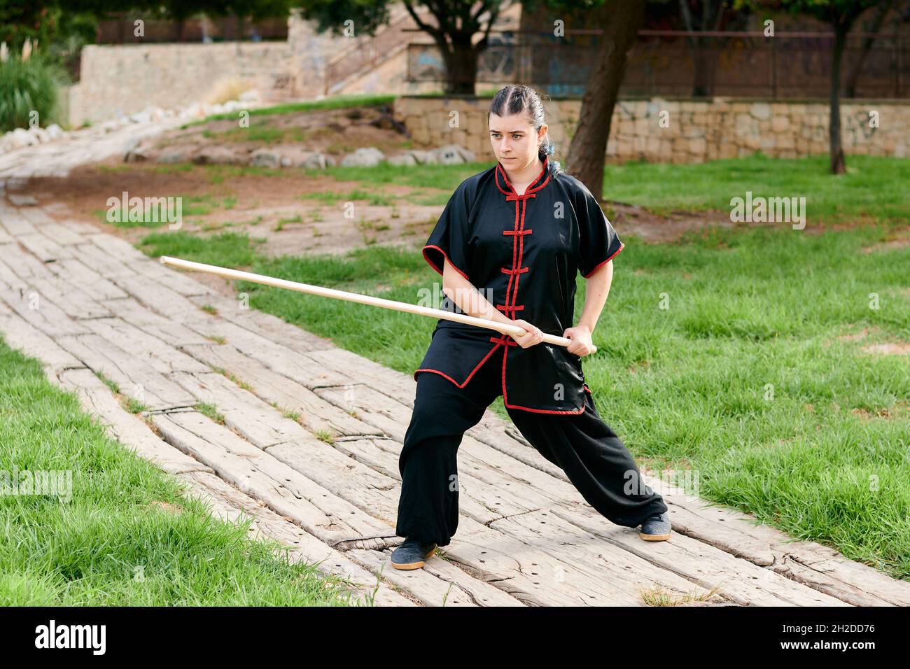 Woman in uniform practicing martial arts with a stick Stock Photo Alamy