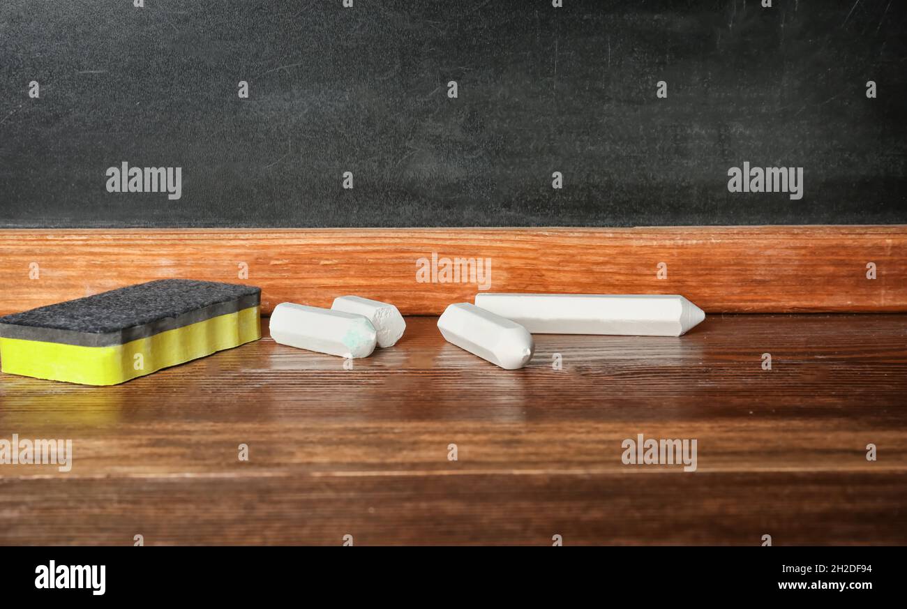 Chalk and duster on table in classroom Stock Photo Alamy