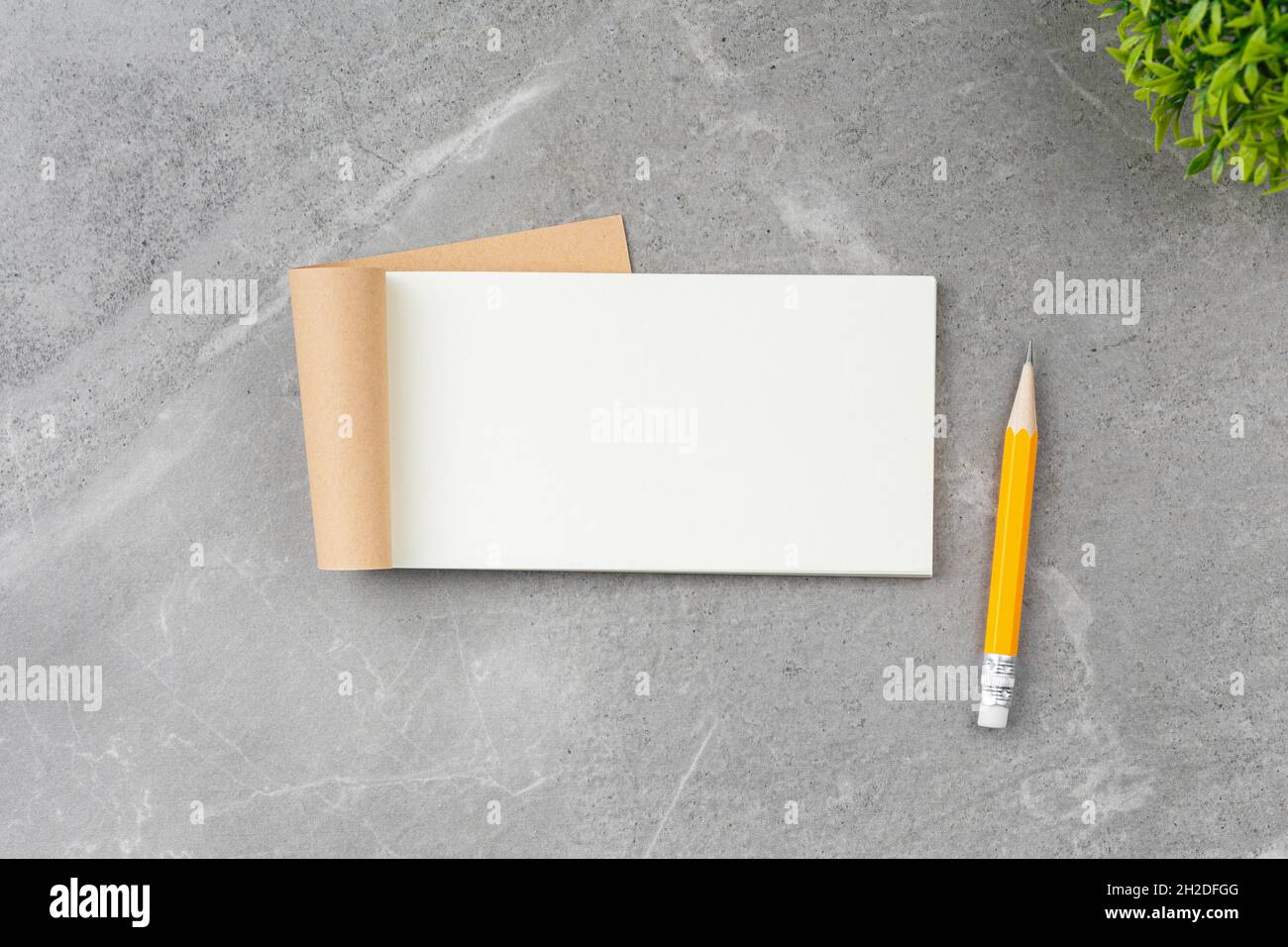 Open notepad on gray marble background. Stock Photo