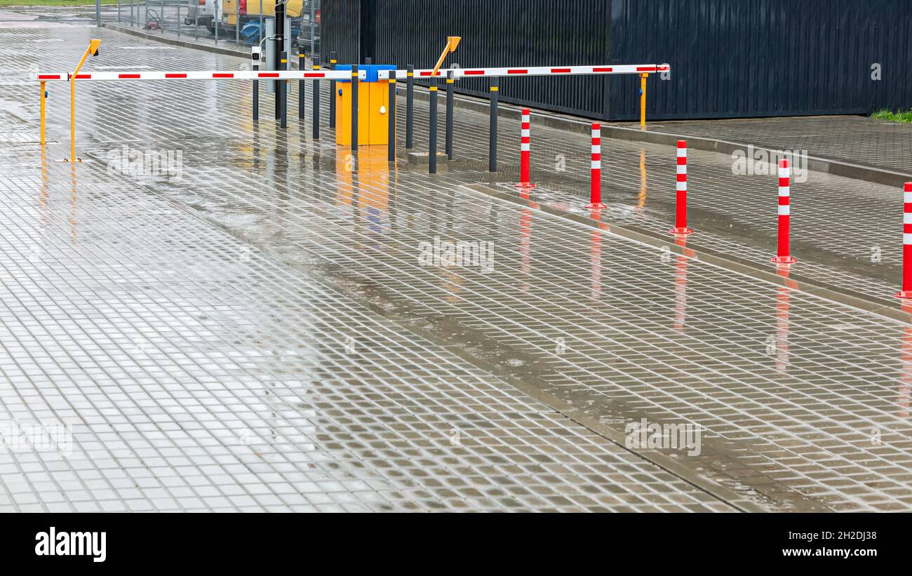 automatic barrier gate in the parking lot. entrance access security system. view at rainy day. Stock Photo