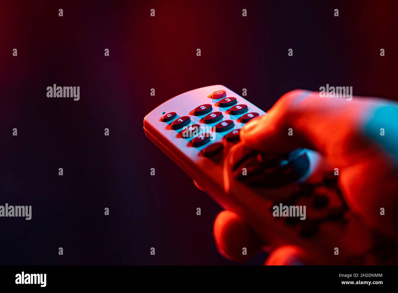 Hold remote control in hand and zap. Male hand is holding TV remote