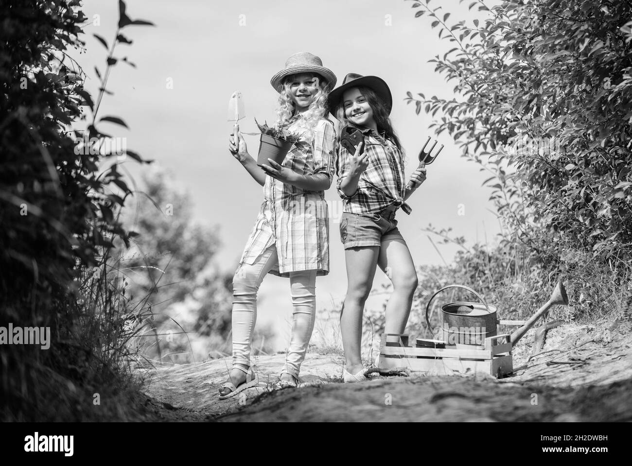 Eco farming concept. On way to family farm. Agriculture concept. Adorable girls in hats going