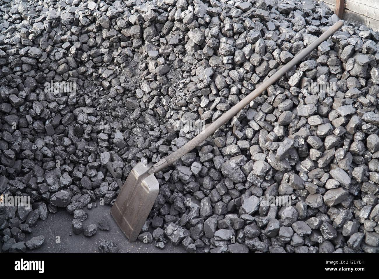 A coal shovel lies on a pile of hard coal necessary to fire an old steam locomotive in the railroad station of Bruchhausen Vilsen, Germany Stock Photo