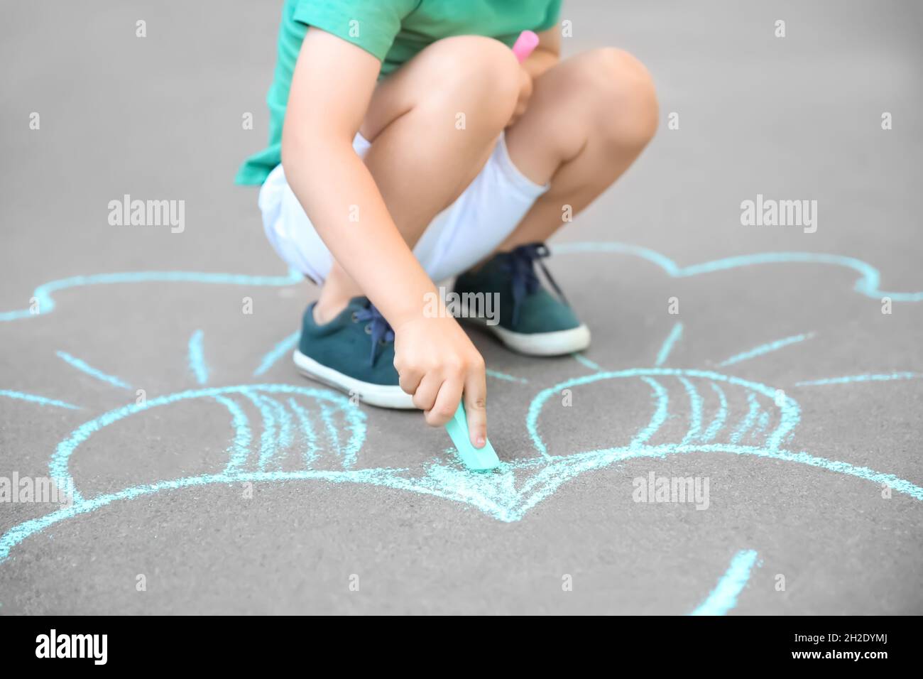 Little child drawing with chalk on asphalt Stock Photo - Alamy