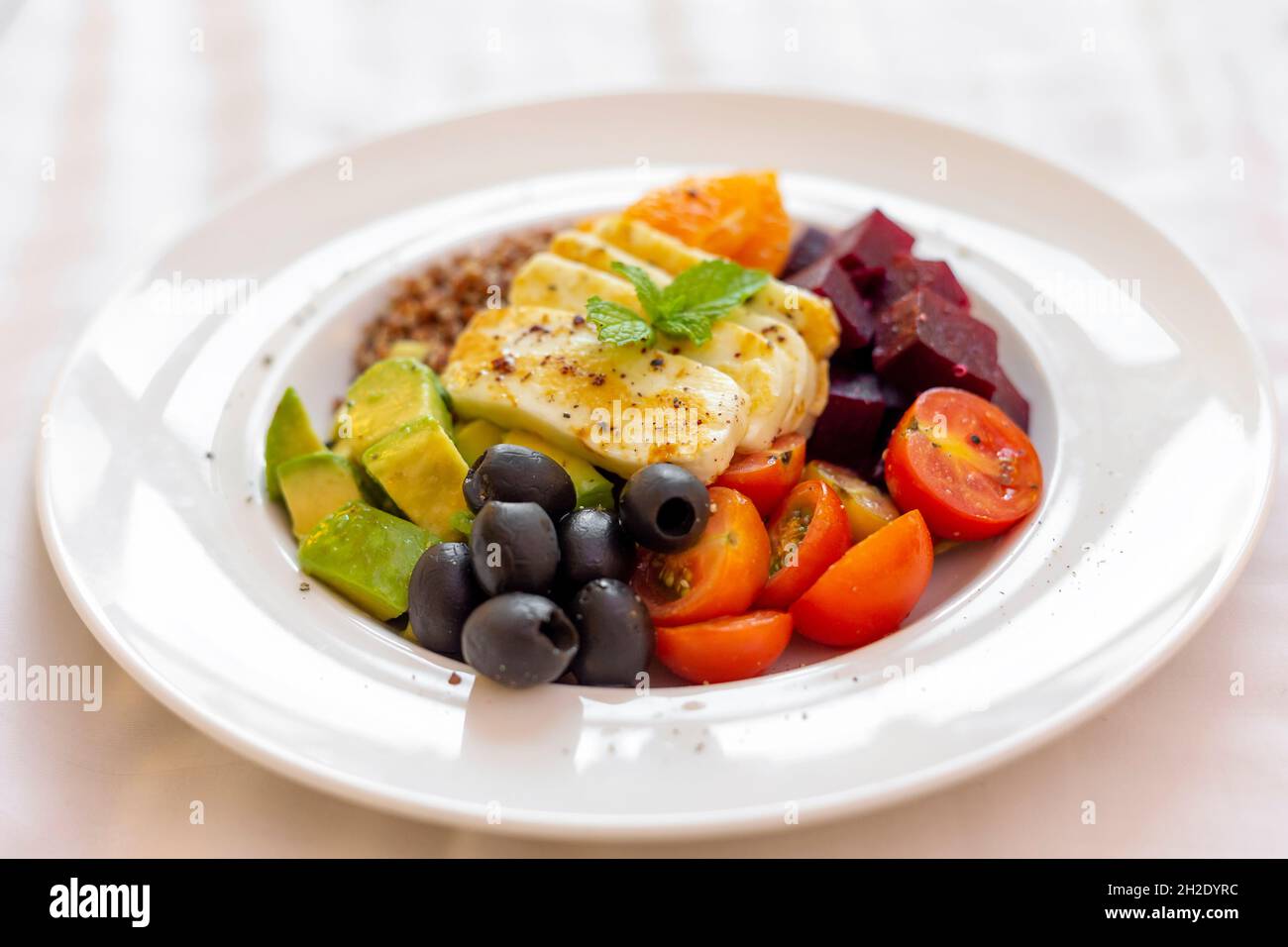 Healthy vegetables and grilled cheese salad on a plate, closeup Stock Photo