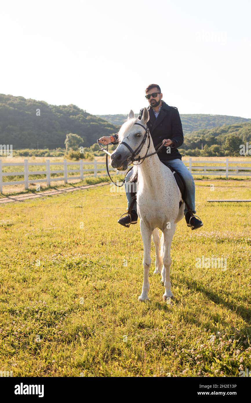 The young man is riding a horse on a farm Stock Photo - Alamy