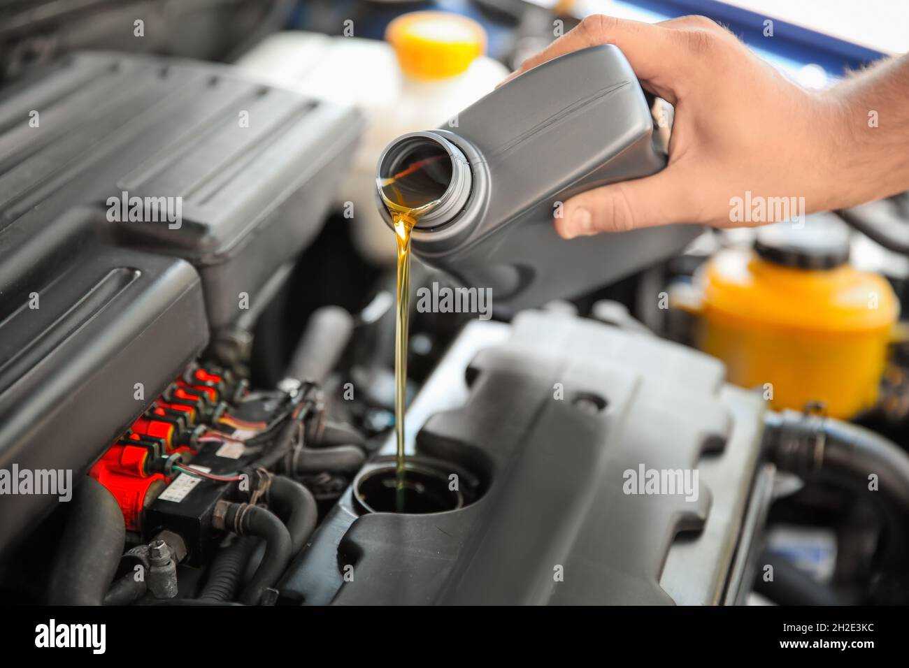 Mechanic pouring oil into car engine, closeup Stock Photo Alamy