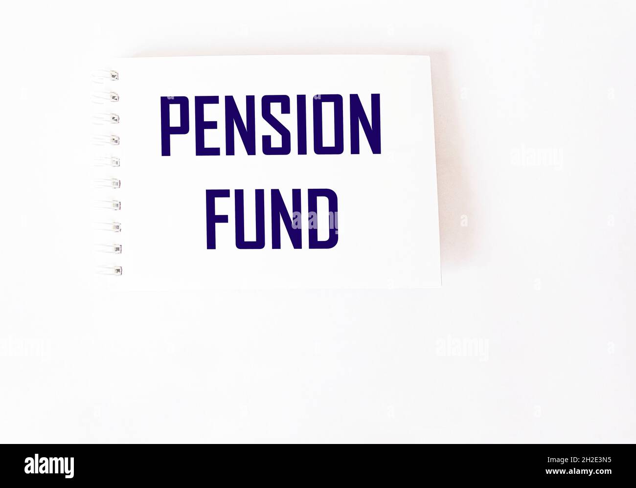 Pension fund, the text is written on a notebook and a white background. Stock Photo