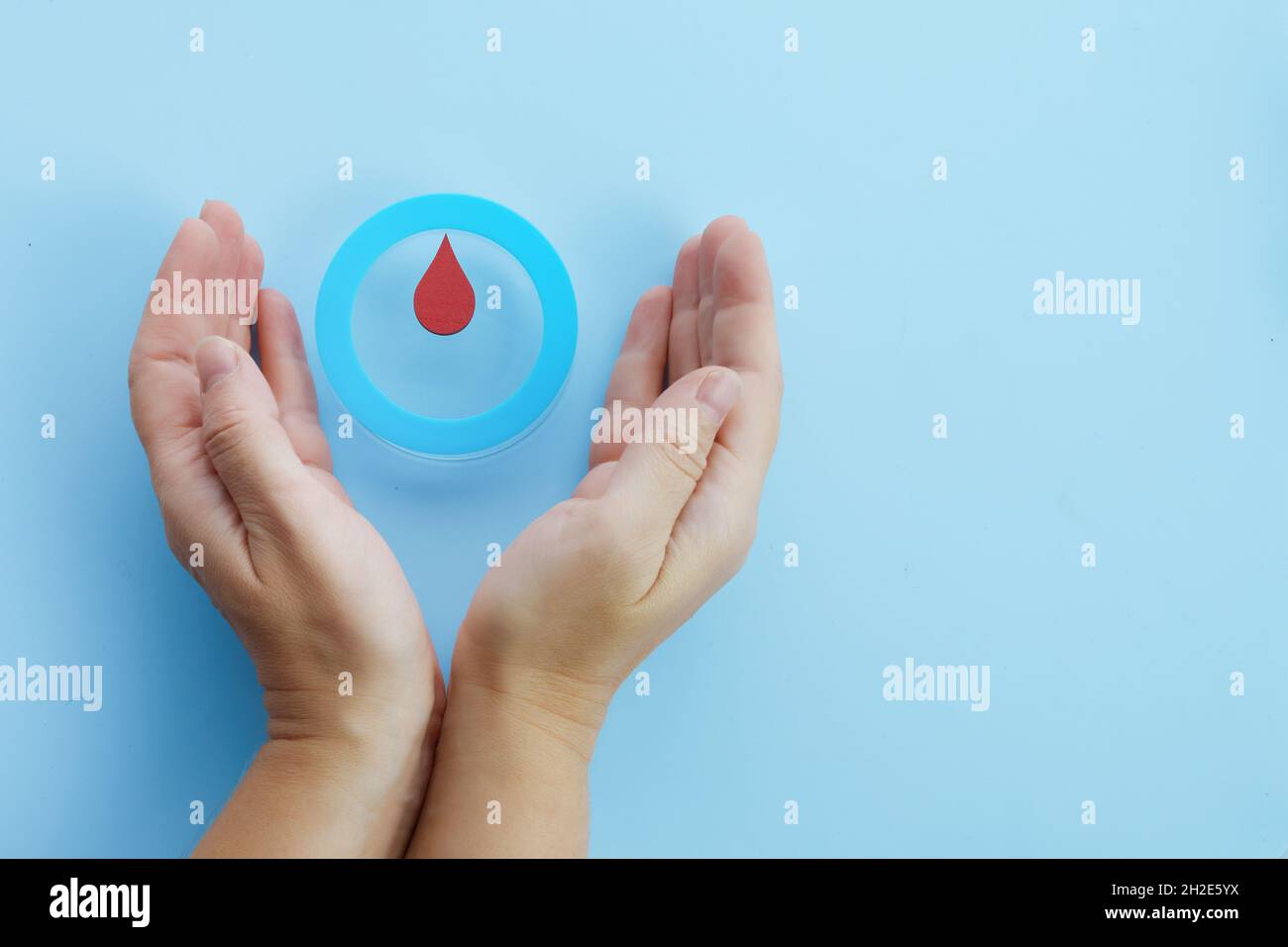 World diabetes day awareness. Woman hands with a blue circle with blood drop, symbol of the diabetes. Stock Photo