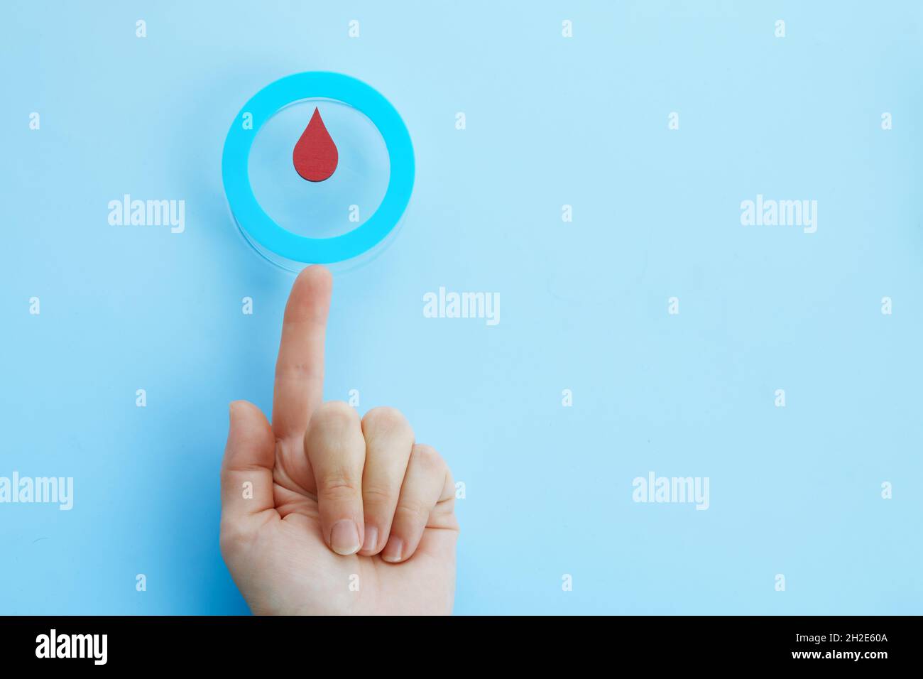 World diabetes day awareness. Woman hand with a blue circle with blood drop, symbol of the diabetes. Stock Photo