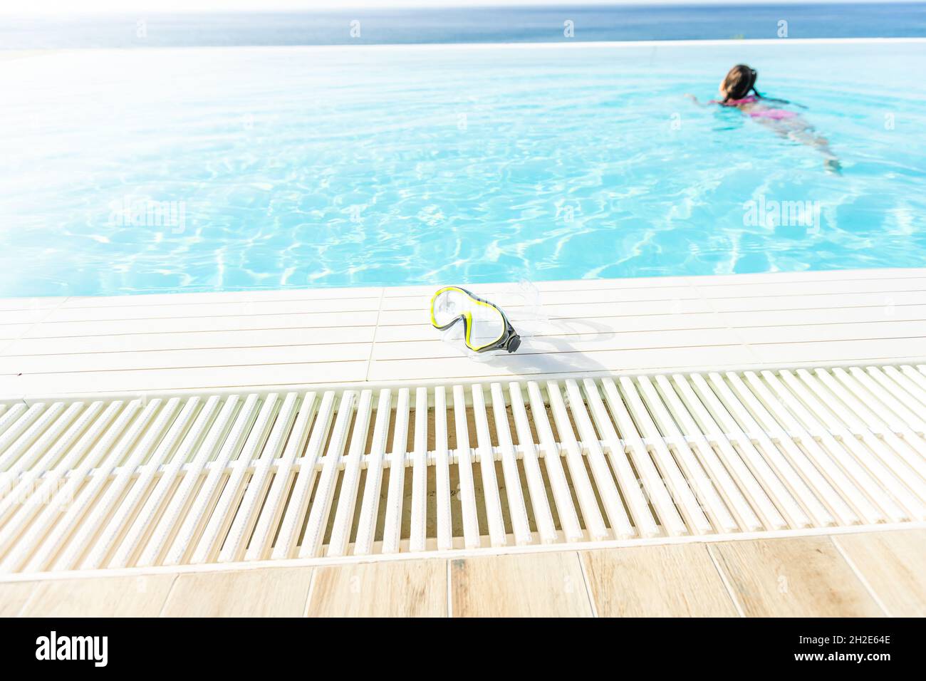 swimming mask with snorkel near the blue pool on a sunny tropical morning Stock Photo