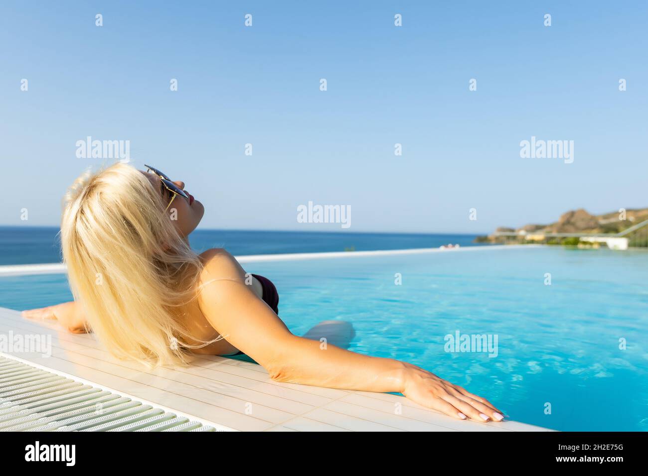 Young woman sunbathing near swimming pool Stock Photo Alamy