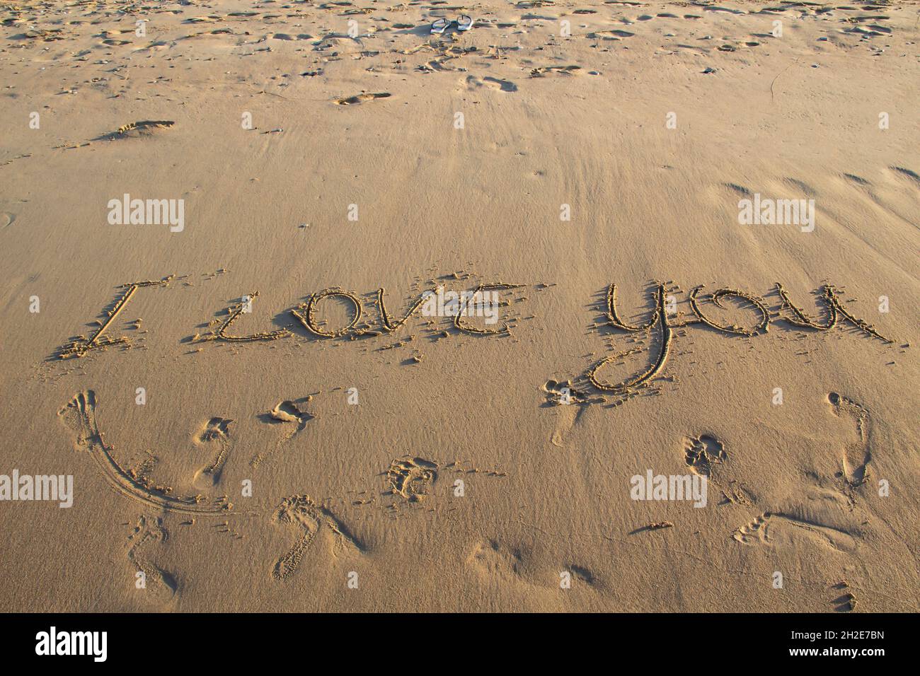Words I Love You writing on the sand on beach against background. Love letters on the sand. Stock Photo