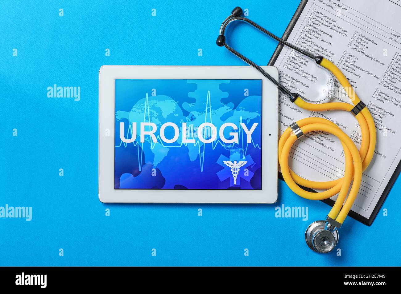 Flat lay composition with tablet, stethoscope and test form on color