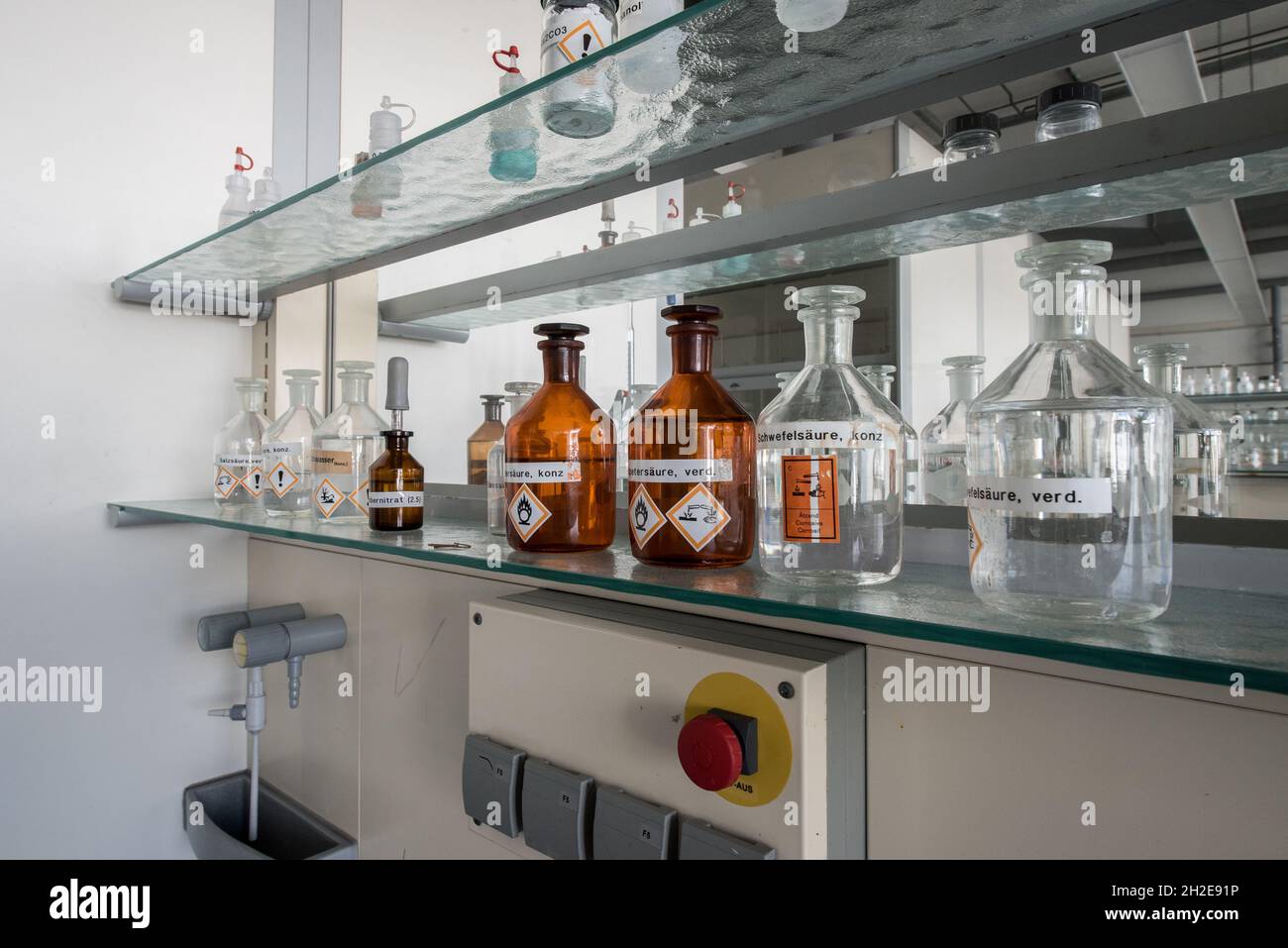 working place in a chemical lab with bottles of acids and bases Stock Photo