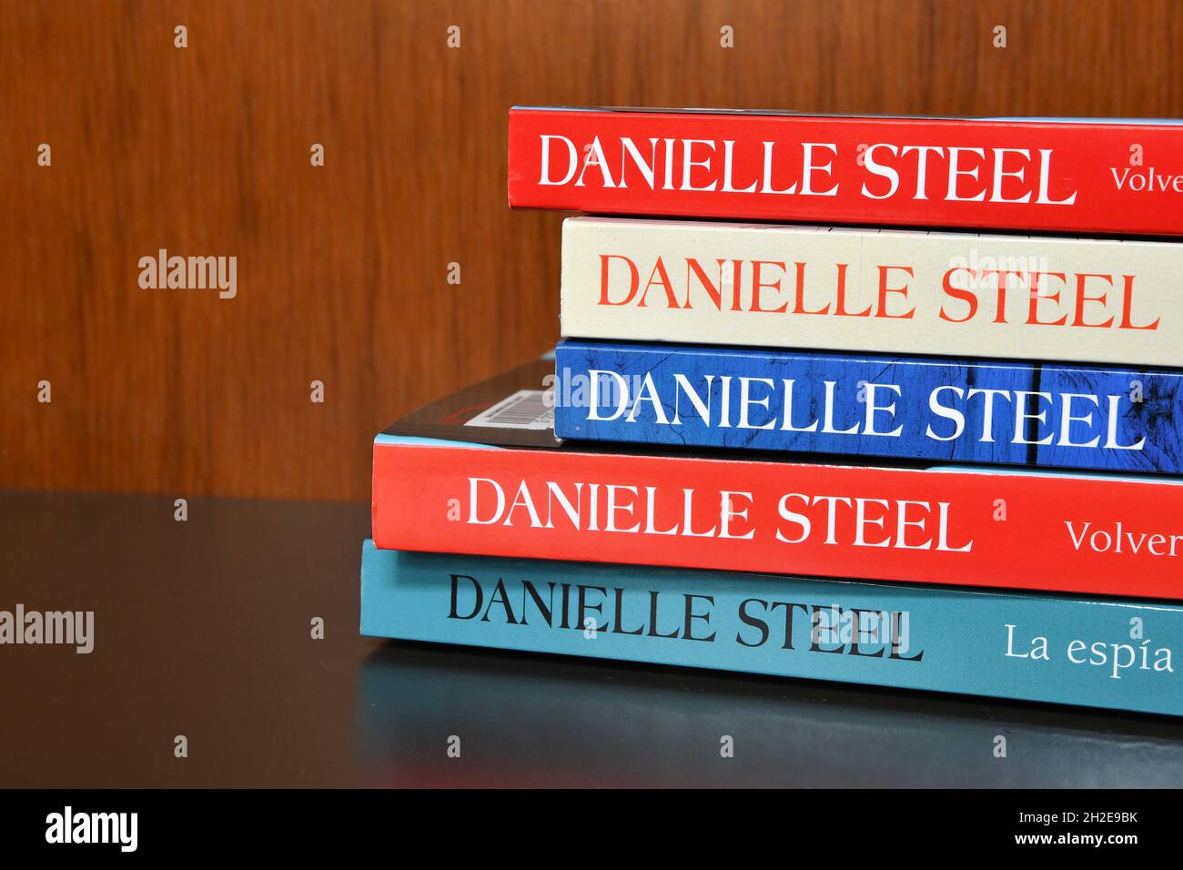 Book spines in various colors of assorted Spanish translations of books by Danielle Steel with the author's name in block capital letters. Stock Photo