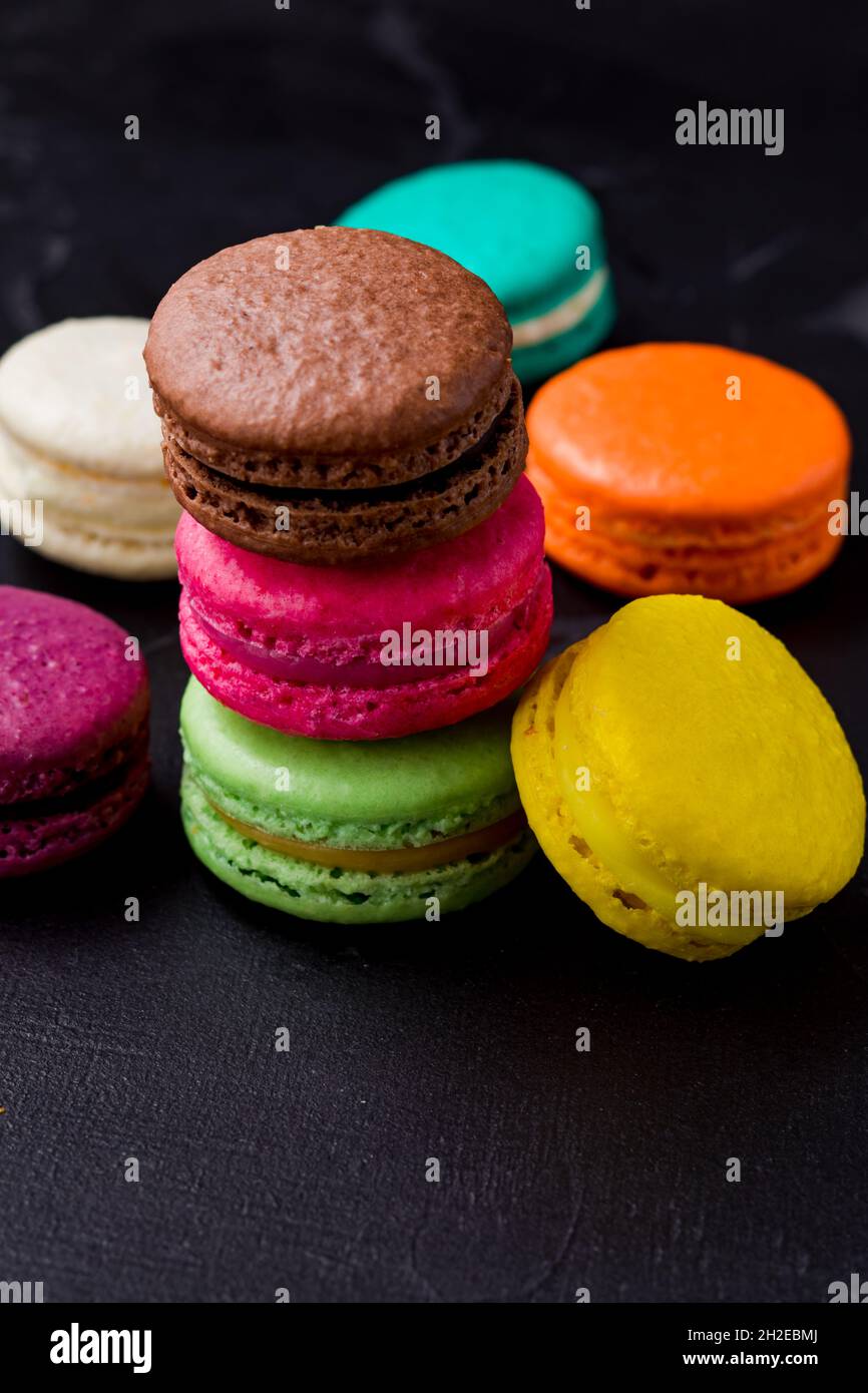 Colorful macarons cookies on the black background Stock Photo