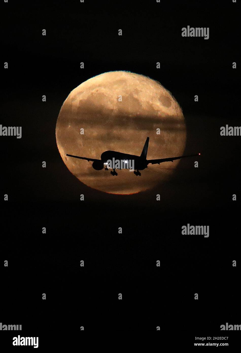 Castle Donington, Derbyshire, UK. 21st October 2021. UK weather.  A plane passes the waning gibbous moon as it makes its approach into East Midlands Airport. Credit Darren Staples/Alamy Live News. Stock Photo