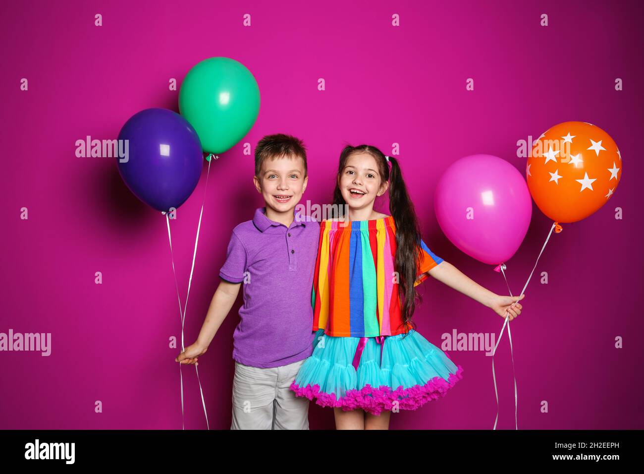 Cute girl and boy with balloons on color background. Birthday celebration Stock Photo Alamy
