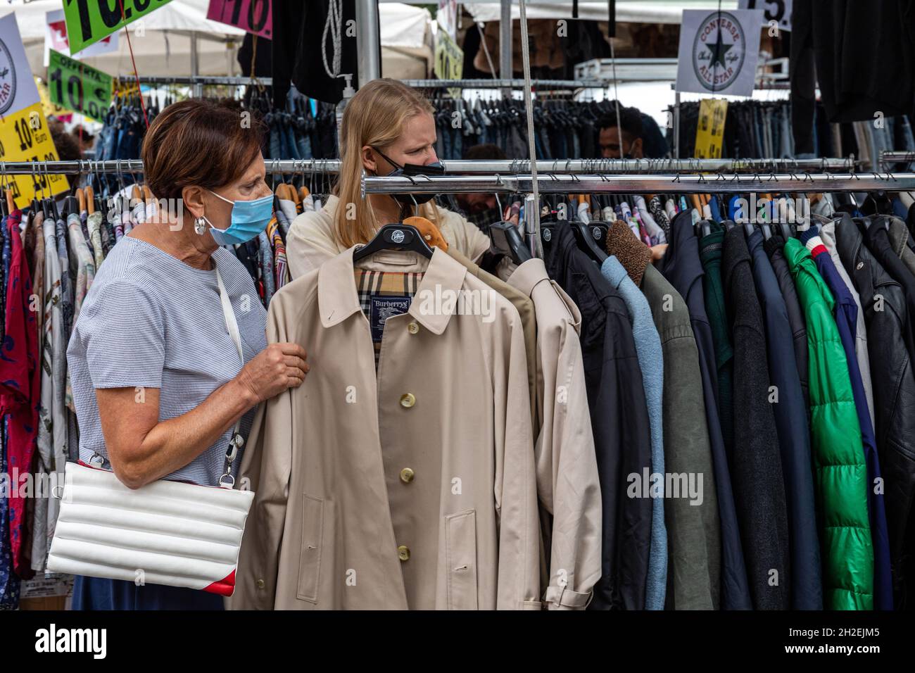 Women browsing rack of overcoats at Mercato di Porta Portese second-hand street market in Trastevere district of Rome, Italy Stock Photo