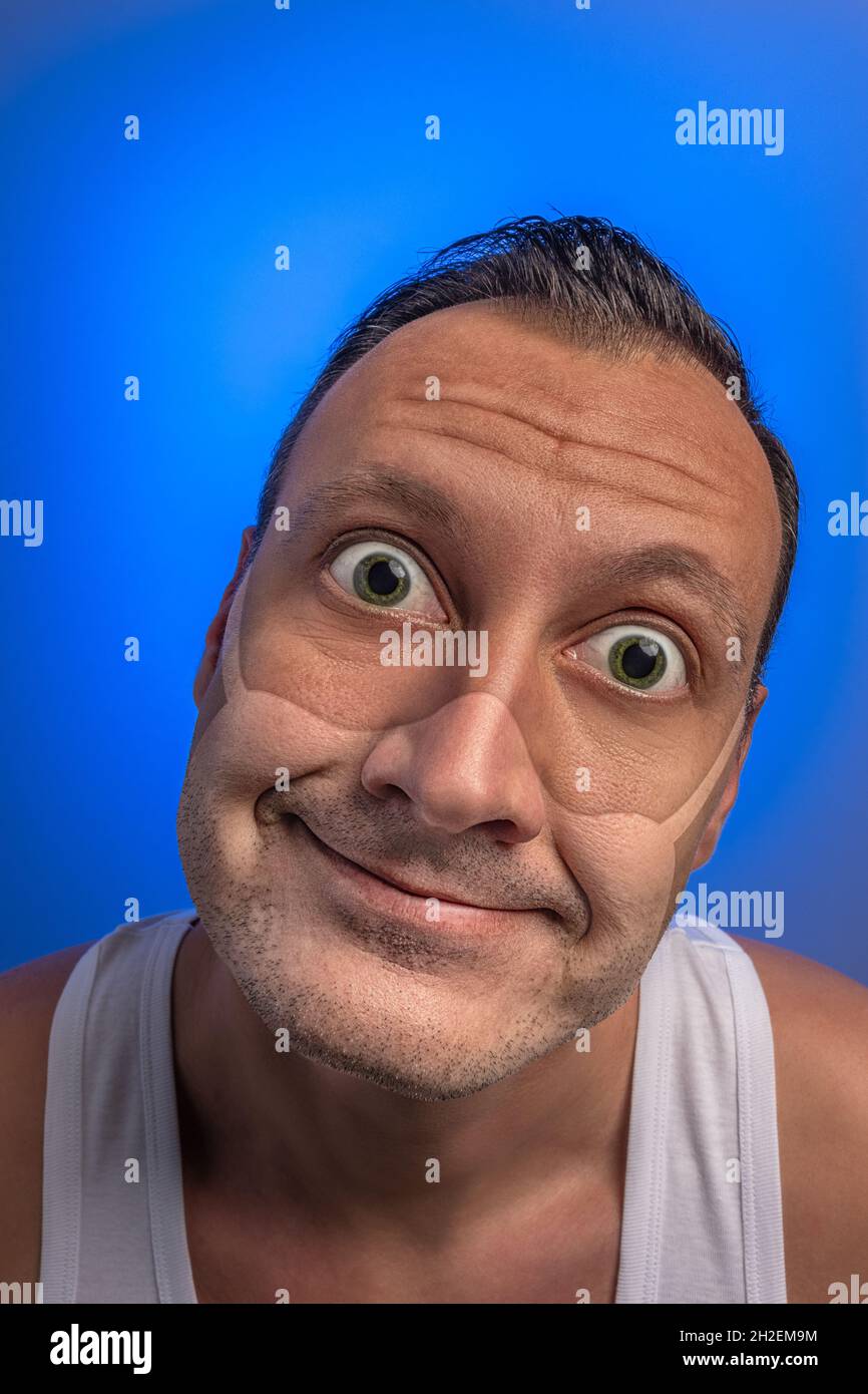 Crazy man with googly eyes with traces of a medical mask. New Corona virus , COVID-19, or 2019-ncov infection novel corona virus disease idea. Stay at Stock Photo