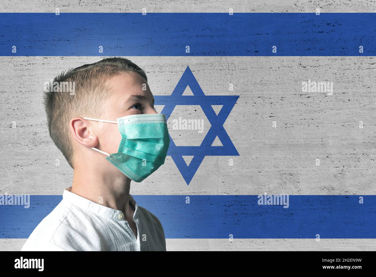 Boy in a medical mask on his face on background of Izrael flag. Epidemic virus 2019-nCoV Respiratory Syndrome. Medicine concept. Stock Photo