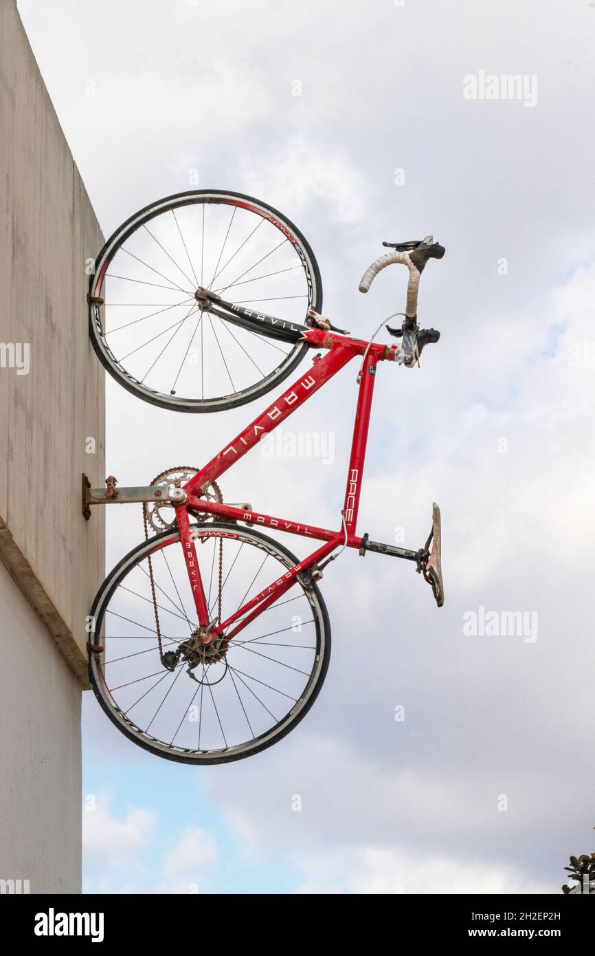 racing road bike mounted vertically on wall of velotel bicycle hire