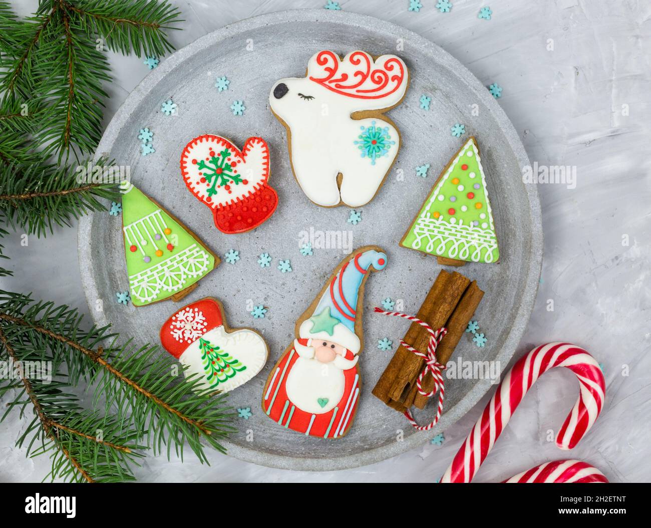 Christmas gingerbread cookies on a gray tray next to fir tree branches. Mockup with copy space. New Year greeting card, decorations. Close up Stock Photo