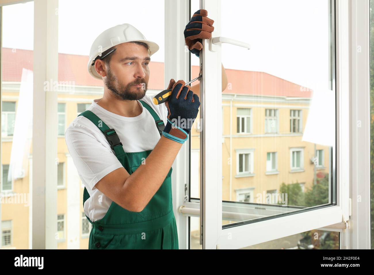 Construction worker installing new window in house Stock Photo - Alamy