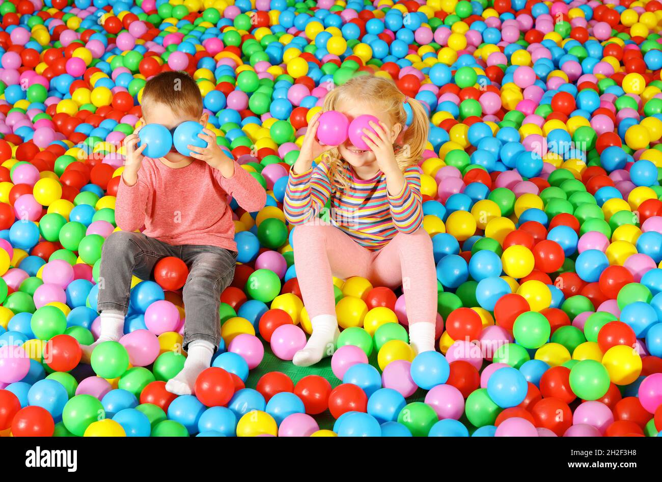 Cute children playing in ball pit indoors Stock Photo Alamy