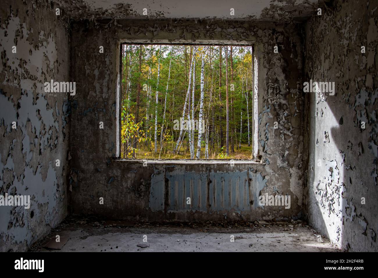 View through the hole for a windows in a damaged abandoned panel house. Stock Photo
