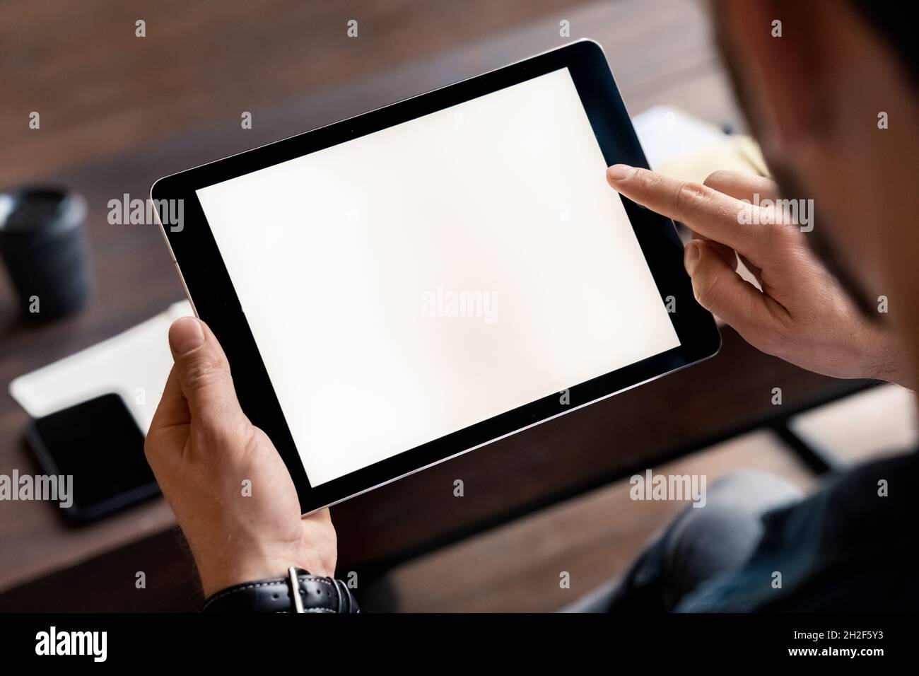 Digital tablet device white screen in male hand over tablet mockup