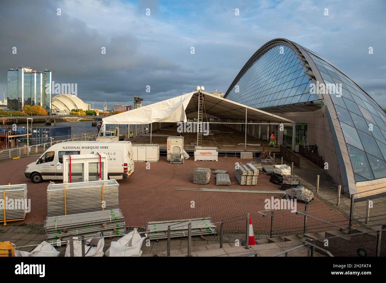 Glasgow, Scotland, UK. 21st Oct, 2021. PICTURED: Workmen continue to construct the large tent like temporary structures, this one being outside of the Science Centre. 10 days until the start of COP26. The COP26 site showing temporary structures half built on the grounds of the Scottish Event Campus (SEC) Previously known as Scottish Exhibition and Conference Centre (SECC). Security fences with a ‘ring of steel' encapsulates the COP26 conference site. CCTV stations with emergency lights and loudspeakers are positioned all over the site. Credit: Colin Fisher/Alamy Live News Stock Photo