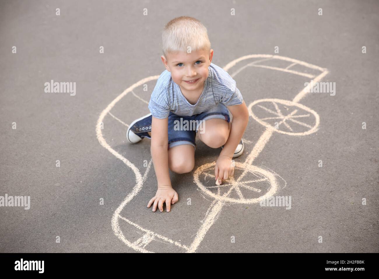 Little child drawing car with chalk on asphalt Stock Photo - Alamy