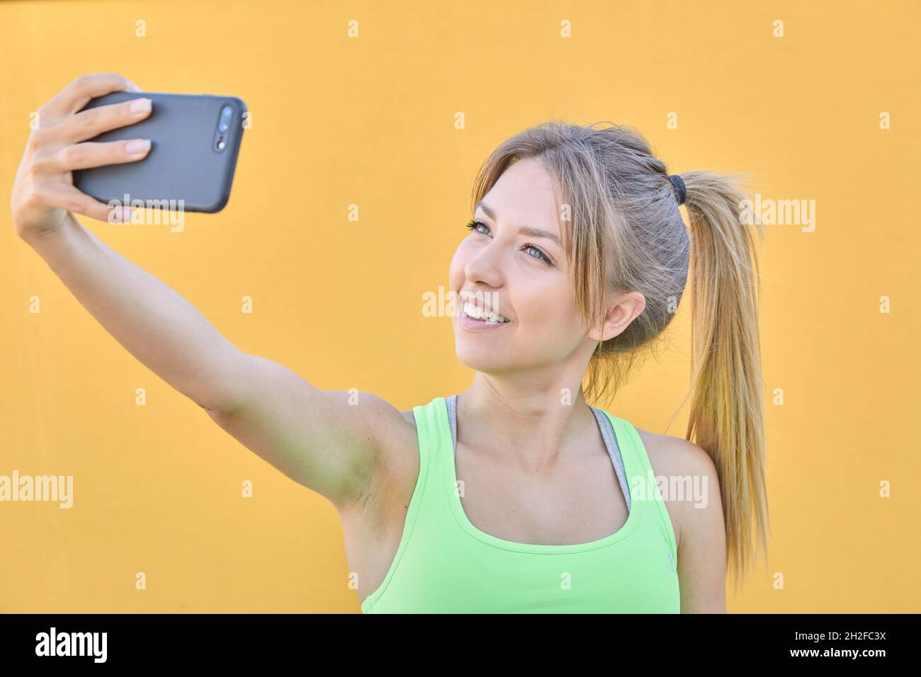 Pretty blonde girl doing a selfie with her cell phone Stock Photo - Alamy