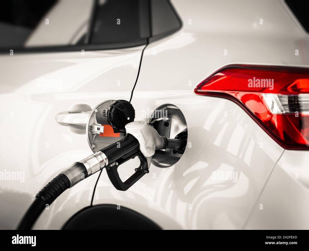SUV big new car refueling at petrol gas station to filling with gasoline or diesel fuel. Refuel fueling pump nozzle pistol gun Stock Photo