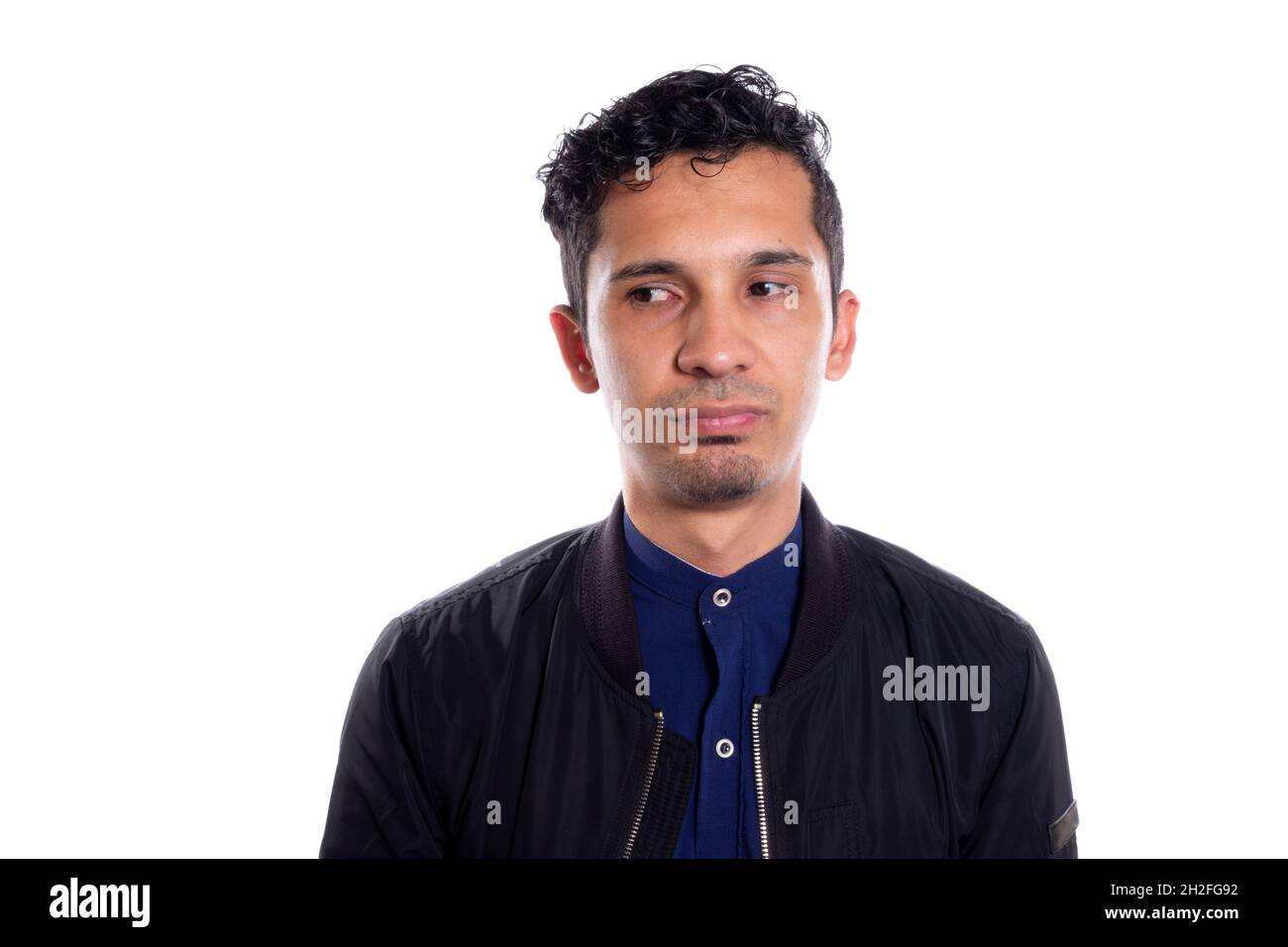 Latin man with dissatisfied face. On white background. Unamused Face. The grumpy, sullen gaze expresses dissatisfaction. Stock Photo